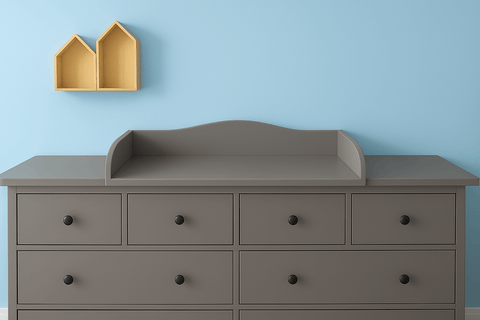 Eine graue Kommode (KraftKids Wickelaufsatz grau für 160 cm HEMNES) steht vor einer hellblauen Wand; darüber bilden zwei gelbe hausförmige Regale auf der linken Seite eine charmante Wickelstation.