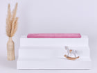 Eine dreistufige weiße IKEA TROFAST Sitzbank mit einem KraftKids GmbH Sitzauflage für Ikea TROFAST Cord Breitcord Rosa Kissen auf der obersten Stufe, einer Vase mit Pampasgras auf der linken Seite und einem kleinen weißen Schaukelpferd auf der unteren rechten Seite.