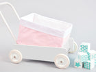 Das Körbchen kleine Blätter rosa auf Weiß von KraftKids, ein weißes Spielzeugkörbchen mit rosa blattgemustertem Stoff, wird neben pastellfarbenen Spielzeugblöcken mit Zahlen und Mustern auf hellgrauem Hintergrund gezeigt.