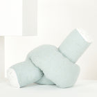 Eine KraftKids Wickeltischumrandung aus Musselin mit goldenen Punkten auf grün wird vor einem minimalistischen weißen, geometrischen Hintergrund präsentiert.