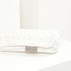 Eine gefaltete weiße Babydecke Musselin mit goldenen Punkten von KraftKids liegt auf weißem Untergrund. Perfekt als Decke für Ihr Baby.