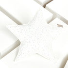 Das Sternkissen Musselin goldene Punkte auf Weiß von KraftKids liegt auf weißen, rechteckigen Blöcken - ein bezauberndes Accessoire fürs Kinderzimmer.