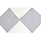 Die KraftKids Decke für Babyschale Winter Musselin grau Punkte hat eine graue Sechseckform mit weißen Punkten, zwei weiße dreieckige Laschen an den gegenüberliegenden Ecken und drei schmale horizontale Gurtschlitze für ein Drei-Punkte-Gurt-System.