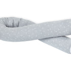 Die KraftKids Wickeltischumrandung Musselin grau Pusteblumen ist eine lange, biegsame, hellgraue Bettumrandung mit einem dezenten weißen Pusteblumenmuster, das in einer losen Schlaufe auf weißem Hintergrund abgebildet ist.