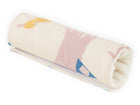 Ein aufgerollter KraftKids Armschoner Babyschale Musselin Zoe's Dinosaurier auf Beige mit niedlichen Dinosaurier-Prints auf Beige - ideal als weiche, stylische Armauflage für den Autositz Ihres Babys.