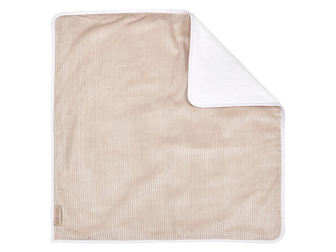 Die KraftKids Wickelunterlage Cord Breitcord Beige Taupe ist eine beigefarbene, rechteckige Wickelunterlage mit gerippter Struktur und weicher weißer Unterseite, die mit einer gefalteten Ecke und einem kleinen Stoffanhänger an einer Kante ordentlich ausgelegt ist.