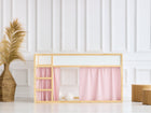 Ein KraftKids Hochbettvorhänge Set 2+1 Doppelkrepp in Rosa, passend für das Kura Bett, verschönert ein minimalistisches Kinderzimmer mit Holzrahmenbett. Eine Korbvase mit Pampasgras und zwei Holzstühle runden die moderne Deko ab.